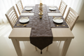 Overhead view of brown faux leather table runner set on light table